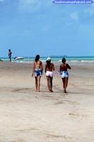 Verso maior do 3 mulheres jovens que andam ao longo da praia em Maragogi, areias brancas.