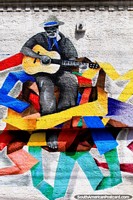 Man plays an acoustic guitar, a fantastic mural with nice colors in Natal. Brazil, South America.