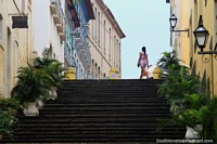 Looking up stairs, street lamps, ferns, old buildings and a model, historic center in Sao Luis. Brazil, South America.