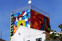 A fantastic mural of a woman in color high at the top of a building in central Belo Horizonte.