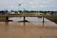 Larger version of Acre River with one of 3 bridge crossings in central Rio Branco, yellow and green flag flying.