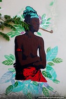 A native man wearing red and green smokes a pipe, street art in Rio Branco. Brazil, South America.