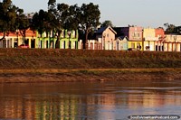 Las casas históricas en colores pastel brillan en el río Acre en la hora dorada de Río Branco. Brasil, Sudamerica.
