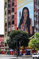 Larger version of Young indigenous woman with a spear, huge mural on a building side in Manaus.