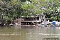 Large wooden house built on the riverbanks with the jungle behind in Manaus. Brazil, South America.