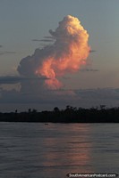 A huge cloud illuminated by the light of the forthcoming Amazon sunset on the river.