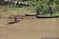 Boys fishing from their hand-carved wooden canoes in the Amazon. Brazil, South America.