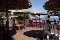 Área de praia em Alter do Chão com mesas, cadeiras e guarda-sóis na beira da água. Brasil, América do Sul.