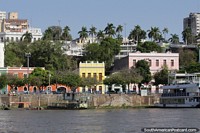 Waterfront in Corumba with historic buildings painted in bright colors, view from the river. Brazil, South America.