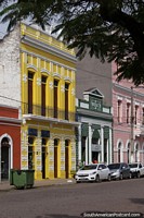 Row of colorfully painted historic buildings (1914) in Corumba, yellow, green and pink. Brazil, South America.