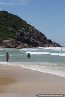 Waves crash in at Brava Beach in Florianopolis, surrounding rock boulders. Brazil, South America.