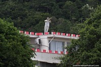 Hombre usando un telescopio desde lo alto de una casa en Barra da Lagoa en Florianpolis. Brasil, Sudamerica.