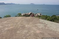 Huge rock face and view down to the coast and sea at Barra da Lagoa in Florianopolis. Brazil, South America.