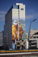 Man playing a wind instrument, huge mural on a building side in Porto Alegre. Brazil, South America.