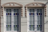 Pair of symmetrical windows with decoration and colored glass in Pelotas.