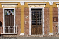Fachada de ladrillo con puertas y contraventanas de madera con revestimiento de azulejos y cermica en Alegrete.