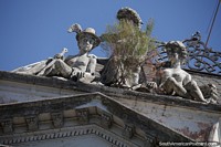 Figuras de cerâmica espreitam do topo de um edifício histórico em Uruguaiana.