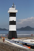 Black and white striped lighthouse on the beach in Santos.