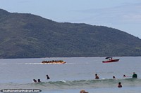 Paseo en barco banana transportando a muchas personas en la Playa Grande de Ubatuba.