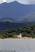 Church in front of the sea surrounded by rainforest and mountains in Paraty.