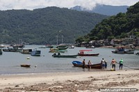 Los pescadores locales arrojaron un bote al agua en la playa de Mangaratiba.