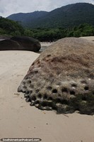 Roca con agujeros erosionados por el agua en la playa de Caxadaco en Isla Grande.