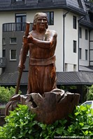 Larger version of Mapuche paddles a canoe, great wooden sculpture in the plaza in Pucon.