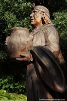 Larger version of Mapuche holding an urn, wooden sculpture in the plaza in Pucon.