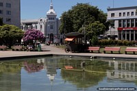 Chile Photo - Water feature and fountain at the plaza in Osorno with the 1927 building in the corner.
