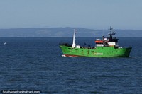 Large green trawler heads out to sea from Puerto Montt.