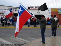 As pessoas mantêm bandeiras e tambores de pancada no momento de um protesto em Calama. Chile, América do Sul.