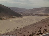 Heading south out of Arica, a huge and bleak valley below. Chile, South America.