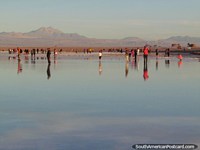 Many groups all together at days end enjoying the beginning of sunset at a reflecting lagoon, San Pedro de Atacama. Chile, South America.