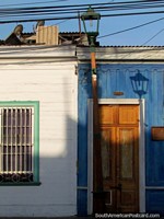 Casa azul, puerta de madera, farol y sombra en Iquique. Chile, Sudamerica.