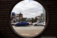 View of Puerto Montt through a round window, hotel, municipal and Ripley buildings. Chile, South America.