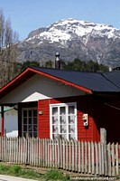 Casa vermelha de madeira em Futaleufu, as casas têm pilhas de lenha e chaminés. Chile, América do Sul.