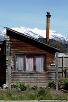Wooden house with a steel chimney stack in Futaleufu, cold place in winter. Chile, South America.