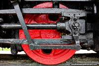 Black engine and red wheel of a train at the plaza of old trains in Castro.