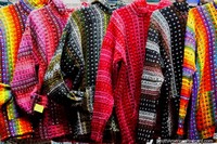 Versión más grande de Jerseys gruesos y coloridos, brillantes como un arco iris, hechos de lana en el mercado de artesanías en Castro.