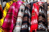 Ponchos tradicionales en diferentes colores para el invierno, disponibles en el mercado de artes y artesanías en Castro. Chile, Sudamerica.