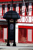 Versão maior do Fachada vermelho-viva e branca e uma cabine telefônica cupulada em Punta Arenas.