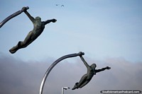 Bronze man and woman want to fly with the birds, monument in Puerto Natales. Chile, South America.