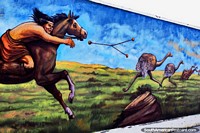A dangerous weapon thrown to kill the emus by an indigenous man on horseback, mural by Eladio Godoy Vera in Puerto Natales. Chile, South America.