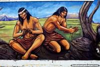 Indigenous people crafting tools and weapons from rope, mural by Eladio Godoy Vera in Puerto Natales. Chile, South America.