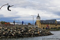 Chile Photo - Seafront in Puerto Natales, hotel with a tower, rocks and a monument.