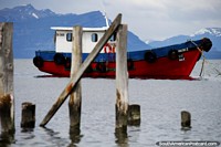 Nat Areno II, barco rojo, azul y blanco amarrado en la bahía de Puerto Natales. Chile, Sudamerica.