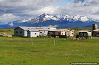 Farmland, buildings and mountains in the countryside between Puerto Natales and Cerro Castillo. Chile, South America.