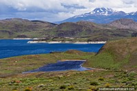 Lake, hills and mountains, traveling the gravel road at Torres del Paine. Chile, South America.