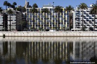 New apartment buildings reflect in the waters of the estuary in Vina del Mar with Brunet Castle above. Chile, South America.
