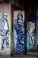 3 columns under a bridge  each with a figure painted upon it, street art in Valparaiso. Chile, South America.